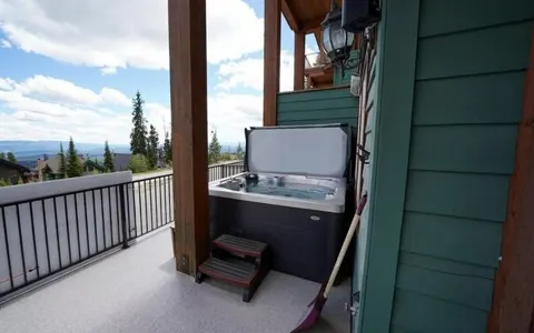 Covered deck with hot tub and valley views